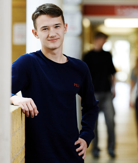 Smilende dreng og to elever i baggrunden